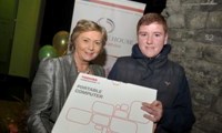 Minister Fitzgerald presents Patrick Collins with a raffle prize of a laptop computer